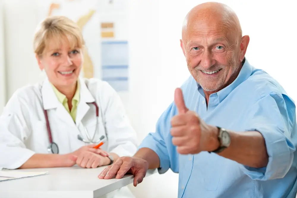 a female doctor smiling and an old man giving a thumbs up