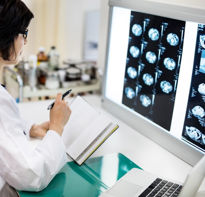 Concentrated female doctor examining MRIs in hospital