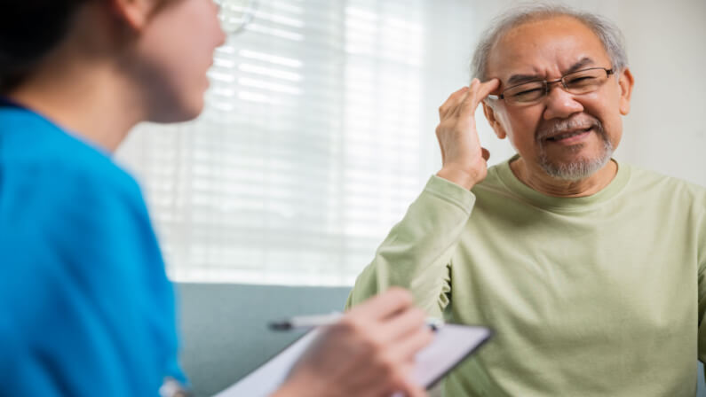 Old Man Consulting an Urgent Care Specialist For Headache