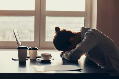 Overworked Tired Businesswoman Sleeping On Table In Office