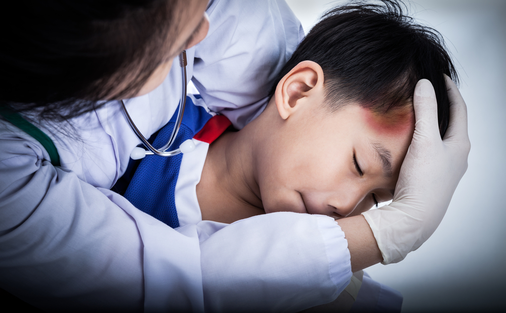 Child temple with a bruise, doctor perform first aid by checking.