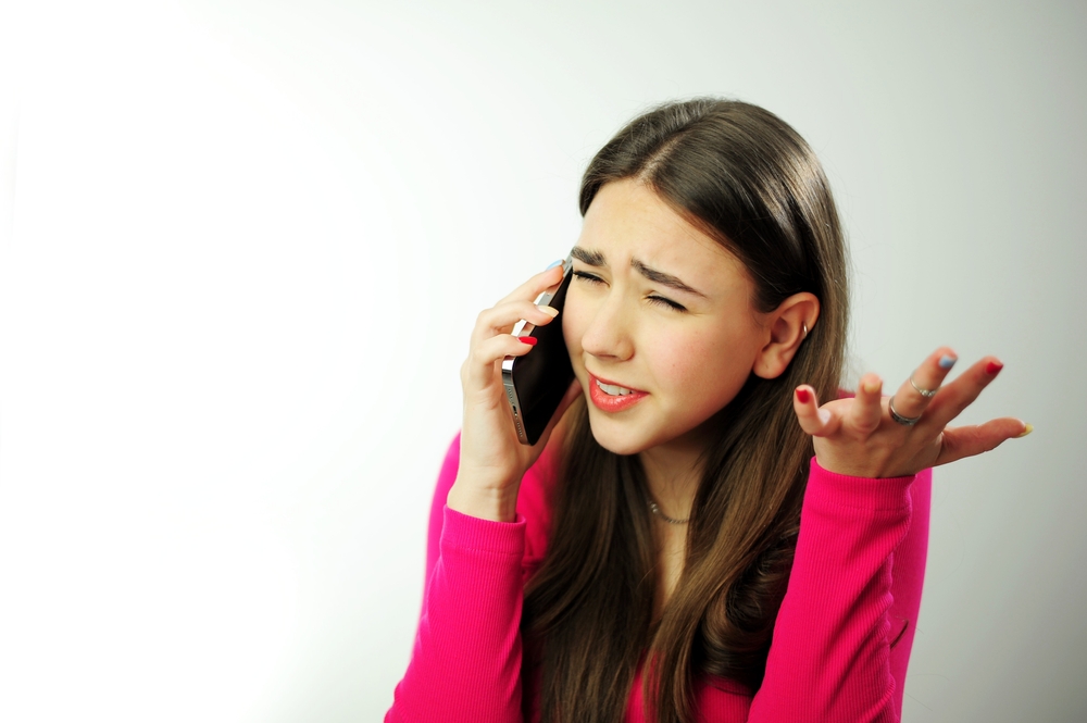 Unhappy young woman feel distressed hear bad news talking speaking on smartphone