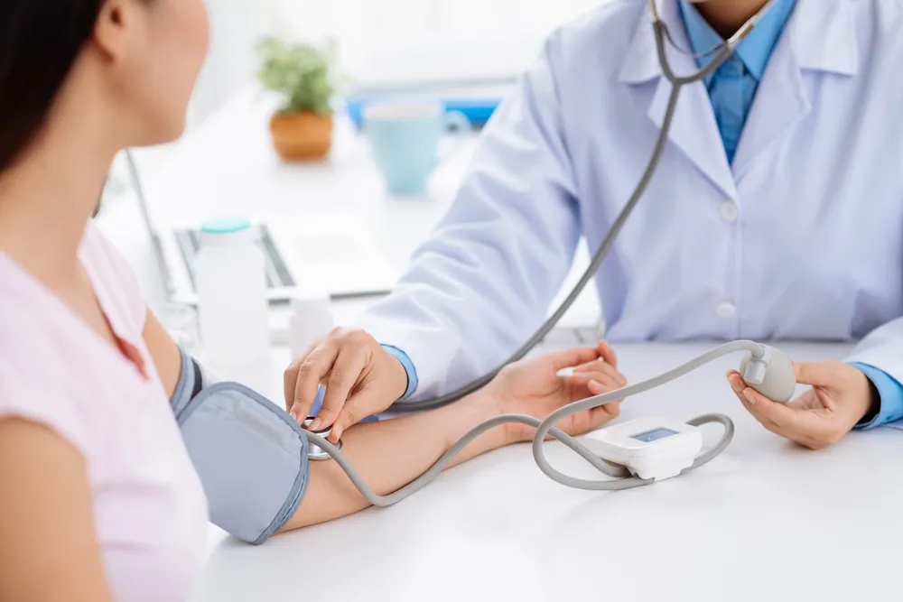 A doctor checking the blood pressure of a client