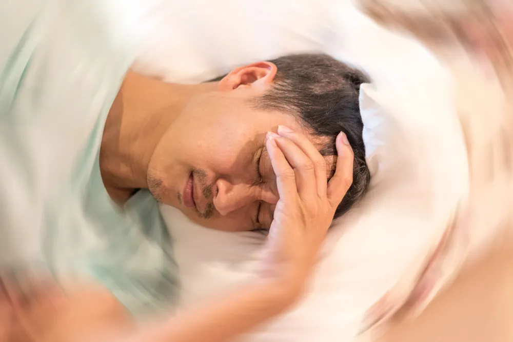 Man hands on his head felling headache dizzy sense of spinning dizziness,a problem with the inner ear, brain, or sensory nerve pathway.