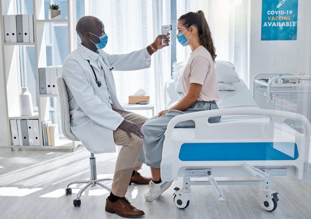 Doctor checking temperature of sick covid patient to test for fever, risk of disease or flu. Physician, gp and corona expert consulting for healthcare, checkup and visit in hospital or medical clinic