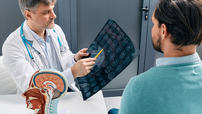 Doctor explaining to male patient results of MRI scan of his brain.