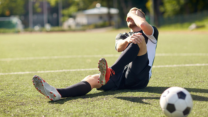 injured soccer player with ball on field